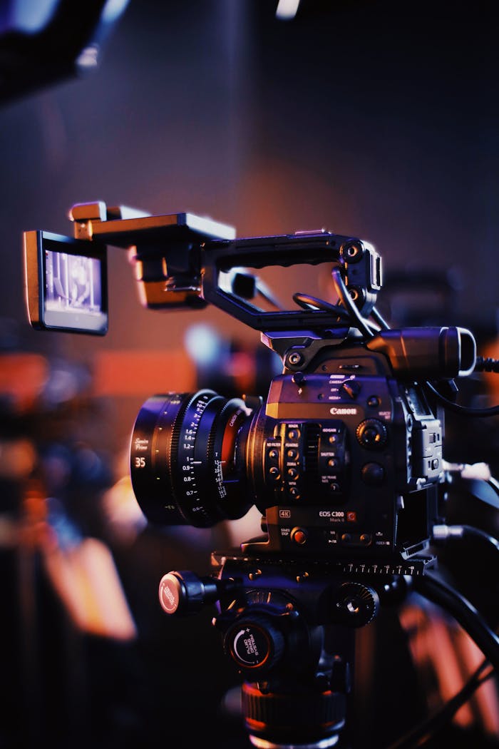 programs-01 Close-up of a professional video camera setup indoors, capturing high-quality footage.